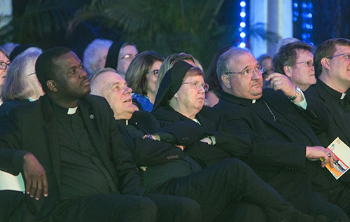 Msgr. Chanel Jeanty, archdiocesan chancellor and St. James pastor, watches the "A Legacy of Faith" documentary alongside Archbishop Thomas Wenski, who was taught by the Sisters of St. Joseph in Lake Worth; Sister Elizabeth Worley, who now serves as his chancellor for administration; and Auxiliary Bishop Peter Baldacchino.