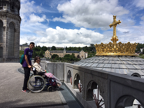 Jean Sanchez (left), a senior from Archbishop Coleman Carroll High, poses with Phyllis, a Lourdes pilgrim, from a viewpoint atop of the Basilica of Our Lady of the Rosary.
