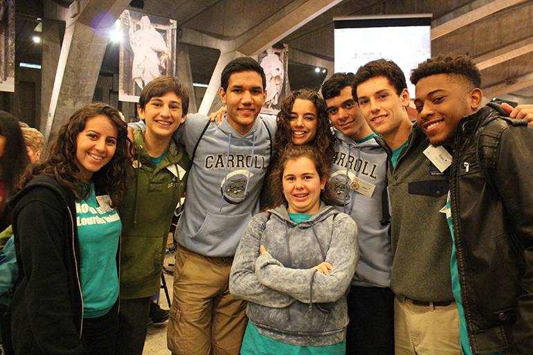 North American Lourdes Volunteers gather for a group shot at the Basilica of St. Pius X, also known informally as the Underground Basilica, found on the ground of the Sanctuary of Our Lady of Lourdes. Among the group of volunteers are students from Coleman Carroll High and the young adult group from Our Lady of Lourdes Parish in Miami.