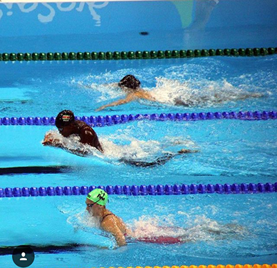 St. Brendan High alumnae Evita Leter is seen here (middle lane) swimming her speciality, the breaststroke, for her native Suriname.
