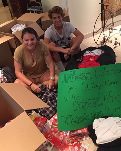 St. Hugh alums Maria Alejandra Mendoza and Eduardo Velazco pose with some of the uniforms they collected over the summer.