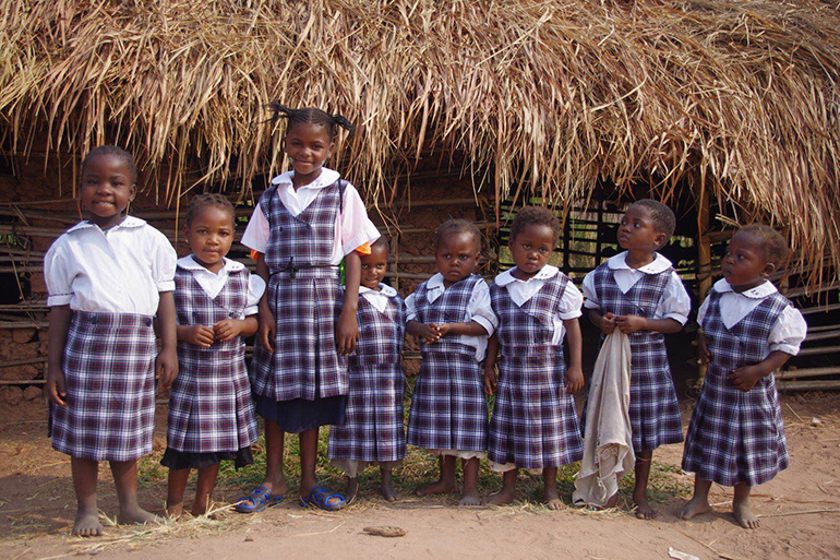 Children in Kasai, Africa, pose in their new uniforms, courtesy of a project led by St. Hugh School alumni Maria Alejandra Mendoza and Eduardo Velazco.