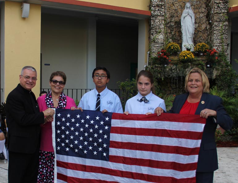 St. Michael the Archangel School kicked off its 65-years celebration Sept. 6. Among the guests were U.S. Congresswoman Ileana Ros-Lehtinen (right) who brought a flag that had been flown over the Capitol Building as a gift to the school. In the photo, from left: Father Francisco Gerardo Diaz, St. Michael's pastor; Carmen Alfonso, school principal; two students; and Ros-Lehtinen.