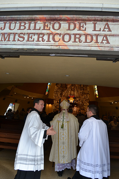 Archbishop Thomas Wenski enters the Shrine of Our Lady of Charity. At left is Father Richard Vigoa, his priest-secretary, and at right is Raul Panellas of the Office of Worship.