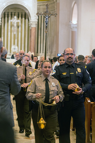 Miami Dade Police Officer Rosa Duran and Sunny Isles Beach Sgt. Ruben Zamora process out of St. Patrick Church after the Mass.