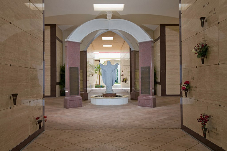 Esta estatua del Sagrado Corazón da la bienvenida a los visitantes al mausoleo de Cristo Rey en el Cementerio Our Lady of Mercy en Doral. Los cementerios católicos de la Arquidiócesis de Miami encarnan las palabras del nuevo documento del Vaticano, de proporcionar un lugar de sepultura digno y "un ambiente que promueva la unidad con Dios".