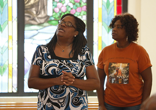 Haitians pray at Notre Dame d'Haiti in Miami Oct. 7 during a first Friday adoration of the Blessed Sacrament. The parish will become a collection point for individual donations of canned proteins and rice for the victims of Hurricane Matthew in Haiti.