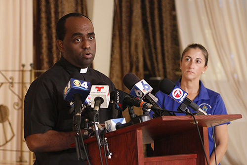 Father Reginald Jean-Mary, administrator of Notre Dame d'Haiti, speaks about the devastation in post-Matthew Haiti as Teresita Gonzalez, executive director of Amor en Accion, looks on.