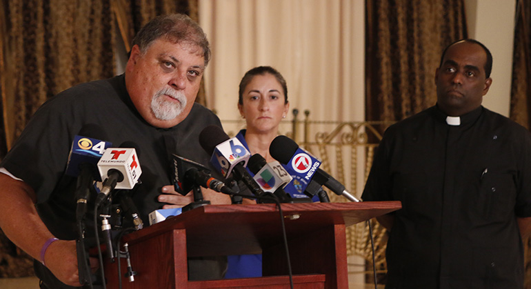 Father Jose Espino, pastor of San Lazaro Church in Hialeah and archdiocesan liaison to Caritas Cuba, explains the post-Matthew situation there as Father Reginald Jean-Mary, administrator of Notre Dame d'Haiti, and Teresita Gonzalez, executive director of Amor en Accion, look on.