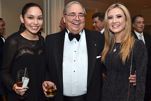 Juan T. O'Naghten, vice president of the Cuban Association of the Knights of Malta, pauses for a photo with two of the younger attendees at the annual White Cross Ball. They include his niece Victoria Pinter, right, and her friend Sofia Rodriguez.