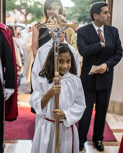 Angelica Santelis, de 9 años de edad, lleva la Cruz a la Misa celebrada por el Arzobispo Thomas Wenski en ocasión del 900 aniversario de la parroquia Little Flower.