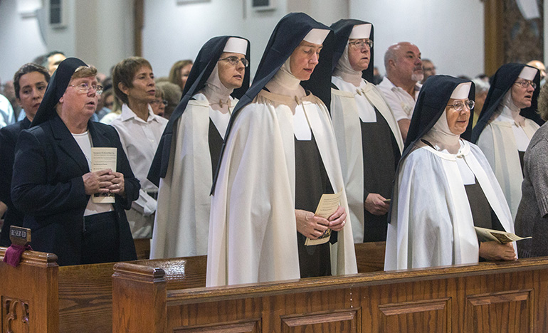 Members of the Carmelites of the Most Sacred Heart of Los Angeles, who teach at St. Theresa School, and Sister Elizabeth Ann Worley, a member of the Sisters of St. Joseph community who taught at the school for 65 years, stand in front rows during Mass.