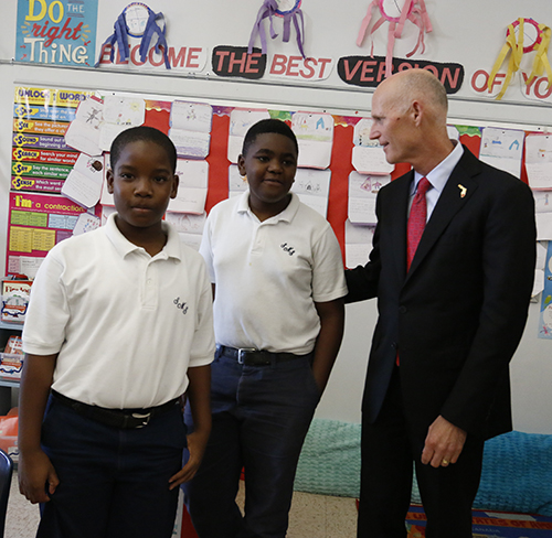 El gobernador de La Florida, Rick Scott habla con los alumnos de quinto grado, Selvin Castro, (izquierda) y Brian Weir durante una visita a la escuela St. Mary Cathedral, el 21 de octubre.