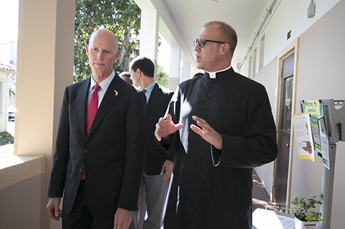 El gobernador de La Florida, Rick Scott habla con el P. Christopher Marino, director de la Catedral St. Mary, durante una visita a la escuela St. Mary Cathedral, el 21 de octubre.