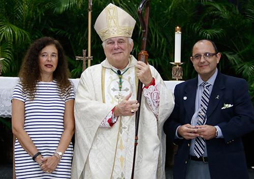 Accompanied by Superintendent of Schools Kim Pryzbylski, Archbishop Thomas Wenski gives the Esperanza Ginoris Award to Miguel Ruiz, director of religious education at Our Lady of Guadalupe Parish in Doral.
