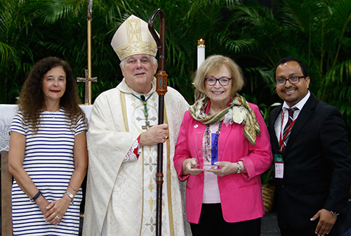 Accompanied by Superintendent of Schools Kim Pryzbylski, left, and Office of Catechesis Director Peter Ductram, Archbishop Thomas Wenski gives a 2016 Catechetical Leadership Award to Therese Walters, director of religious education at San Pablo Church in Marathon.