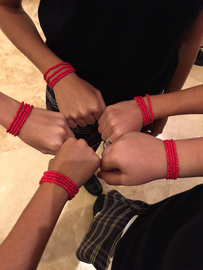 Students involved in St. Hugh's KIDS4KIDS group display the bead bracelets they made for Red Ribbon Week, which also served as a fundraiser for both their school and needy children who attend The Barnyard after-school program.