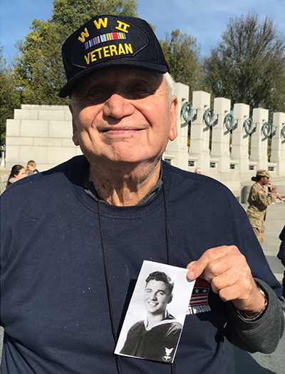 World War II veteran Burton Belenke holds up a picture of his newly-enlisted self during his Oct. 29 visit to Washington, D.C., as part of the Honor Flight South Florida.