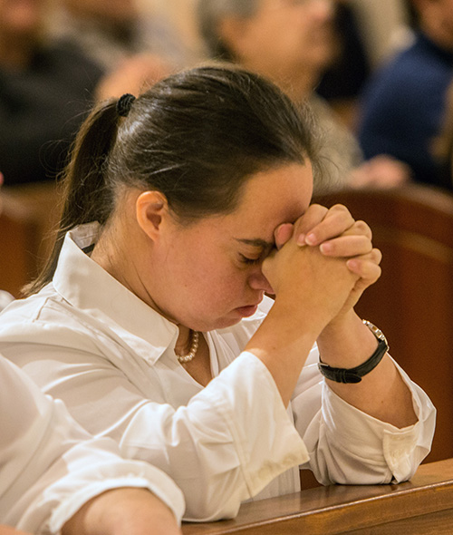 Bernadette Guilarte, from the Marian Center, prays during the Mass for the physically and mentally challenged of Miami-Dade County Nov. 19. Bishop Peter Baldacchino celebrated the Mass at St. Patrick, Miami Beach. The Mass was organized by the Archdiocese of Miami and Best Buddies International.
