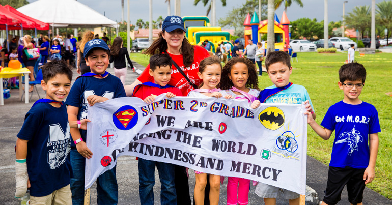 Mother of Our Redeemer School second graders and their teacher, Natalie Argote (center) walk together during a fundraiser for Crohn's disease and colitis held at their school and church grounds.