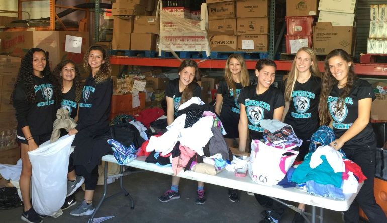 Archbishop McCarthy womenÃ•s soccer team pauses while sorting clothes at Life4Net Families. The team also cooked and cleaned in the organization's kitchen and packed food boxes to be given to families over the Thanksgiving weekend.