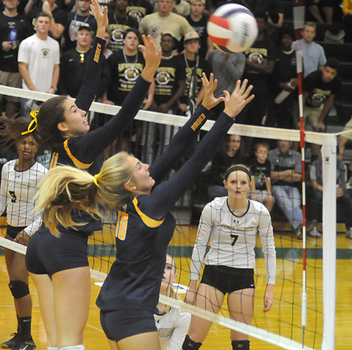 St. Thomas Aquinas' Emma Dixon (11) and Brook Bauer (5) block a Tampa Plant attack in St. Thomas Aquinas' 25-17, 25-21, 25-21 victory over Tampa Plant in the Class 8A state volleyball championship match at West Port High School in Ocala. St. Thomas Aquinas won its third consecutive state title and fifth overall in school history.