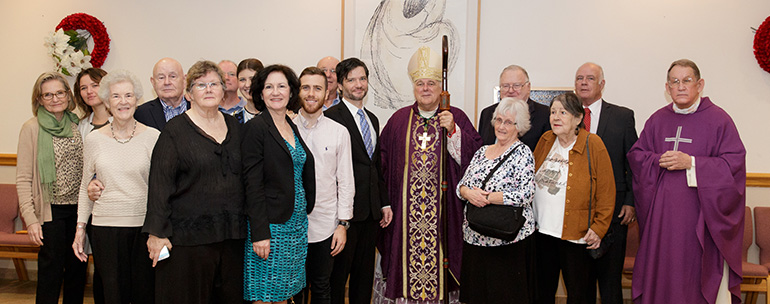 Archbishop Thomas Wenski poses for a photo after dedicating the parish hall at Our Lady of Mercy Church, Deerfield Beach, in honor of former pastor Father Michael Sullivan, who served there from 1995 to 2003 and has been retired since 2005. With Archbishop Wenski are many members of Father Sullivan's extended family, although the priest himself was unable to attend, and Father Kenneth Whittaker, right, the church's current pastor.