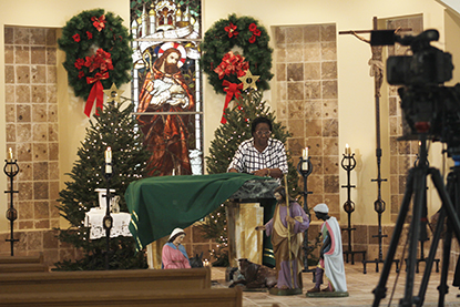 Nereida Delorbe, feligresa de la Misi&oacute;n La Milagrosa ayuda a cambiar los manteles para grabar la Misa en la Misi&oacute;n La Milagrosa, en Miami.