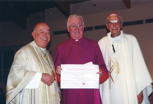 In this picture from January 2000, Msgr. Michael Eivers, displays the papal document that bestows him his new title of monsignor. He is flanked by Archbishop John C. Favalora, left, and Archbishop Edward McCarthy. At the time, Msgr. Eivers was founding pastor of St. Edward Church in Pembroke Pines.