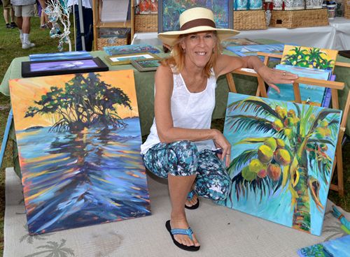 Mary Border of Cudjoe Key poses with her paintings at the Art Under the Oaks Festival.