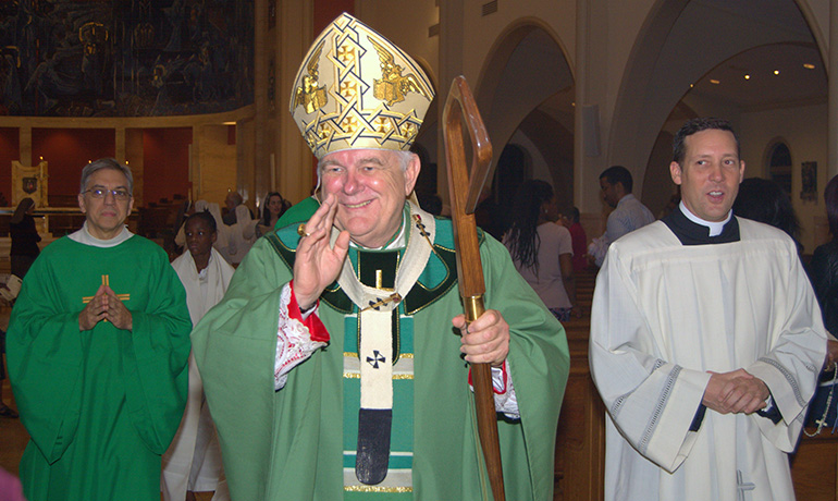 Archbishop Thomas Wenski smiles and waves at the end of the Mass for the World Day of Prayer for Consecrated Life.