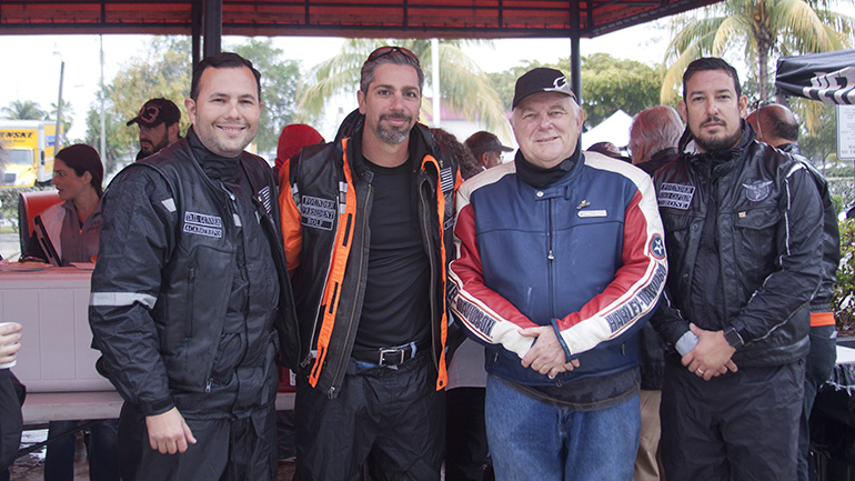 Archbishop Thomas Wenski stands next to members of the Emmaus Bikers from Our Lady of Guadalupe 
Church in Doral. From left: Rodolfo Moreno and Marcus Restrepos, and at far right, Victor Aneas. They are standing outside Peterson’s Harley Davidson in North Miami, the ending spot for the 2017 Archbishop’s Motorcycle Ride.