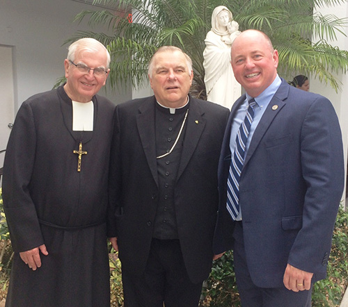 Marist Brother Kevin Handibode, Columbus' president, poses with Archbishop Thomas Wenski and David Pugh, Columbus principal, before a brunch at the Marist Brothers House following the Marist bicentennial Mass.