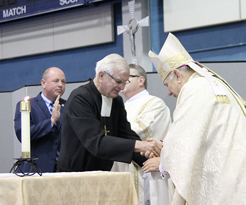 Marist Brother Kevin Handibode, Columbus High School's president, and Principal David Pugh present Archbishop Thomas Wenski with a memento of the Marist Bicentennial during the Mass Feb. 3 at the school.