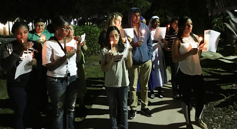 To show solidarity with immigrants and refugees, St. Thomas University students and staff take part in a candlelight vigil Feb. 8 on campus. The vigil was part of the school's response to President Trump's Jan. 27 executive order suspending refugee admissions.
