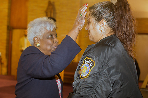 "You are out of the storm!" Sondra Wallace anoints Carmen Sanchez at the end of the first night of the annual black Catholic pre-Lent revival, held Feb. 12-15.