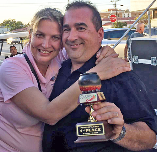 Nelly Palancar and David Carvallo, who ran the winning booth for the Men's Emmaus group from Little Flower Parish in Coral Gables, pose with their People's Choice award. Carvallo did the cooking.