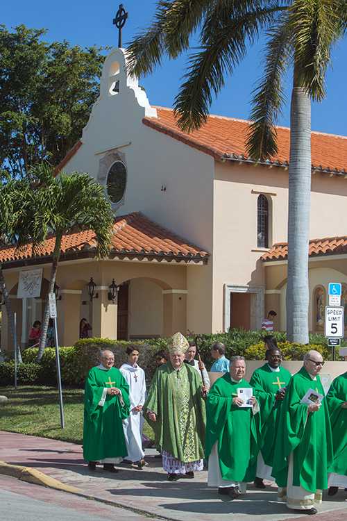 Archbishop Thomas Wenski, Father Juan Sosa, pastor, and others process from St. Joseph Church to Mass site across the street. The parish marked its 75th anniversary Feb. 12 with a single outdoor Mass for the entire community.