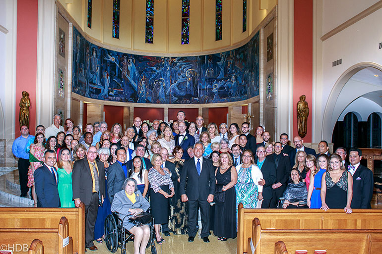 Newlyweds Jeannette Marrero and Daniel Colon pose for a photo surrounded by the community of friends who have helped them throughout their spiritual journey. The spiritual family includes fellow participants in Emmaus retreats, members of Matrimonios en Victoria, and fellow parishioners at St. Agatha Church in Miami.