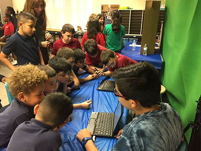 St. Andrew School first-graders learn about the future of cars by listening to middle school students who researched the topic for the Celebrate Engineering Fair.