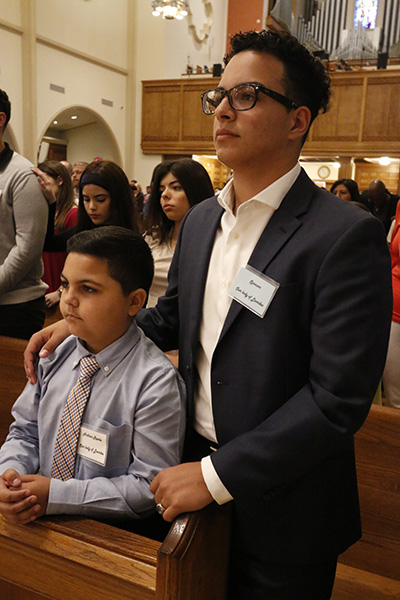 Catechumen Nathan Ravelo, 9, and his sponsor, Andrew Albuerne of Our Lady of Lourdes Parish in Kendall, stand during the first of two Rite of Election ceremonies March 5 at St. Mary Cathedral.