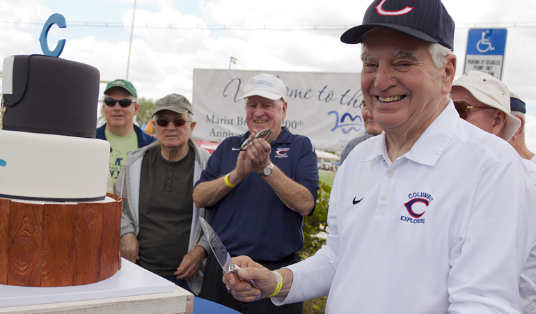 Brother Kevin Handibode, president at Christopher Columbus High School in Miami, cuts a three-tier cake decorated with Marist imagery to mark the Marist Brothers' 200th anniversary.