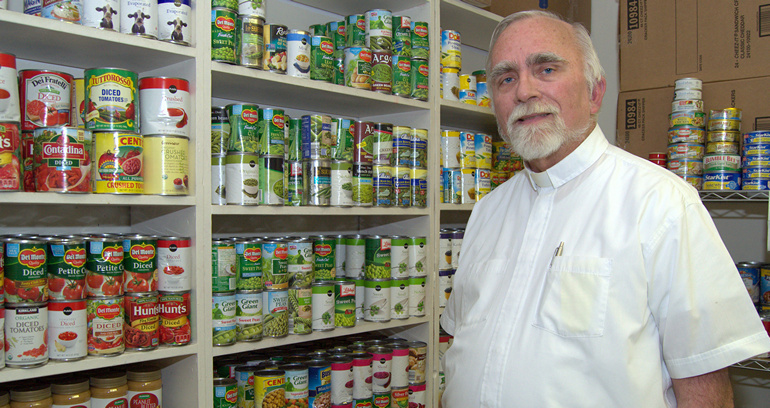 Father Stephen Hilley of St. Justin Martyr shows some of the foods he stocks for the poor on Key Largo.