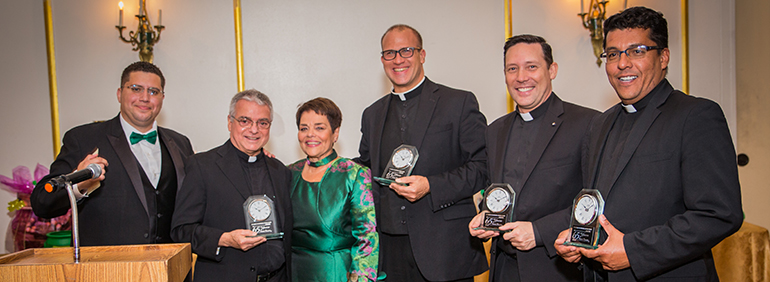 Current and former staff of St. Michael are recognized during the 65th anniversary gala for St. Michael School. From left: Alfonso Balmaceda, religious education coordinator; Father Gerardo Diaz, pastor; Carmen Alfonso, principal; Father Christopher Marino, prior pastor and currently rector of St. Mary Cathedral; Father Richard Vigoa and Father Giovanni Peņa, both former parochial vicars. Father Peņa is now administrator of Prince of Peace Church in Miami and Father Vigoa is secretary to Archbishop Thomas Wenski.