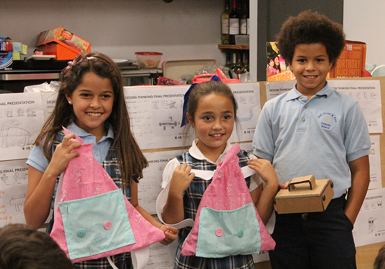 Team Robot members display the backpacks and the coin box they made for their client.