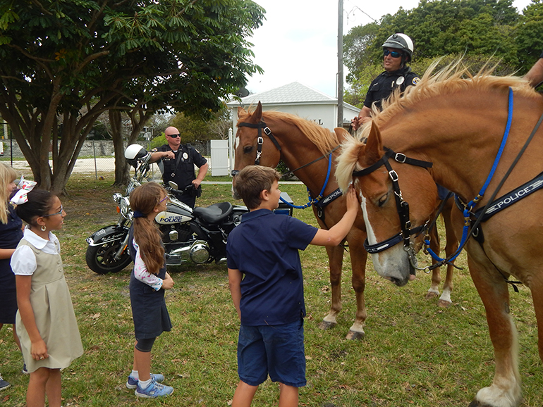 Second graders at the Basilica School of St. Mary Star of the Sea in Key West get up-close and personal with representatives of Key West's mounted and motorcycle police officers.