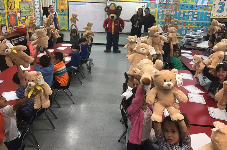 Teddy bears at the ready: Kindergarten students from St. Brendan Elementary hold up teddy bears they made with the assistance of Build-A-Bear for the Parent to Parent community organization.