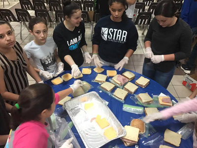 St. Brendan's middle schoolers make sandwiches. They packed 500 meal bags for Camillus House.