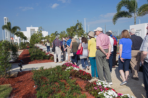 Members of the Conference for Catholic Facility Management walk toward Our Lady of Guadalupe Church along a walkway lined with Marian images. The onsite visit to the Doral church, as well as the Innovation Center at St. Brendan High School in Miami, came at the conclusion of the CCFM's annual meeting, held April 24-26, and hosted by the Archdiocese of Miami.