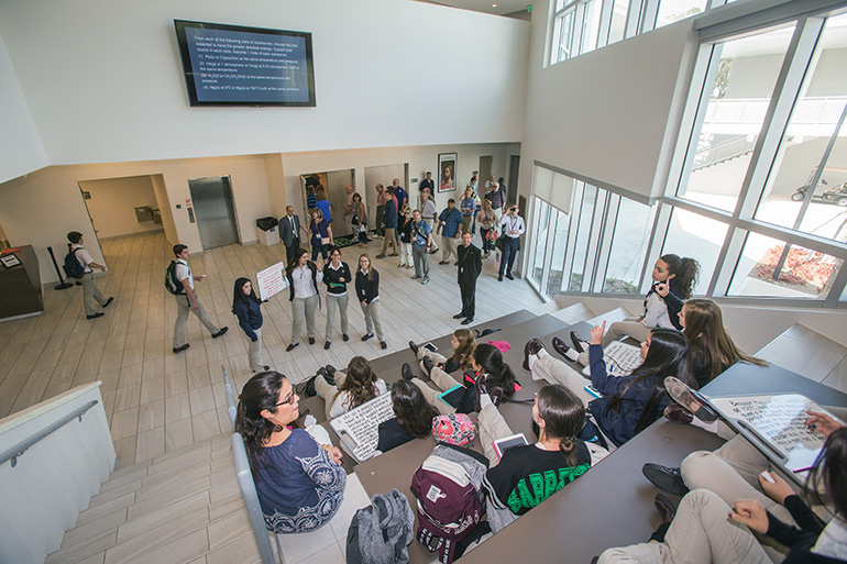 Members of the Conference for Catholic Facility Management enter the Innovation Center at St. Brendan High School in Miami as students take part in an AP chemistry class while sitting on the "social stairs." The onsite visit to St. Brendan, as well as Our Lady of Guadalupe Church in Doral, came at the conclusion of the CCFM's annual meeting, held April 24-26, and hosted by the Archdiocese of Miami.